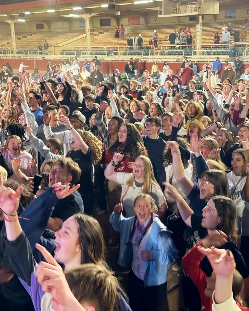 Students cheering with their hands up